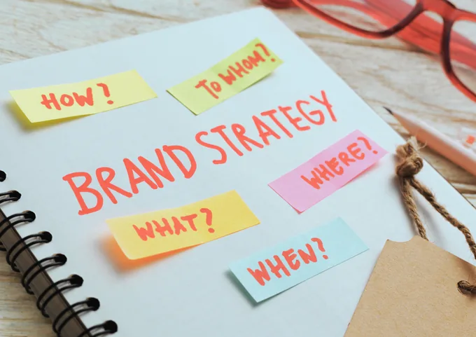 Notas de estrategia de marca sobre un cuaderno: qué, cómo, para quién, dónde y cuándo